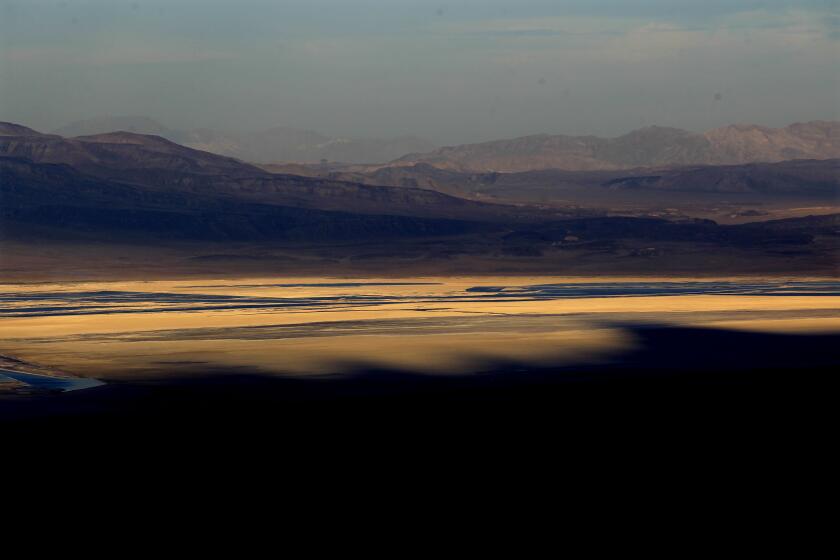 The setting sun casts the shadows of Mt. Whitney and the Sierra Crest across Owens Lake June 11, 2013 near Lone Pine.