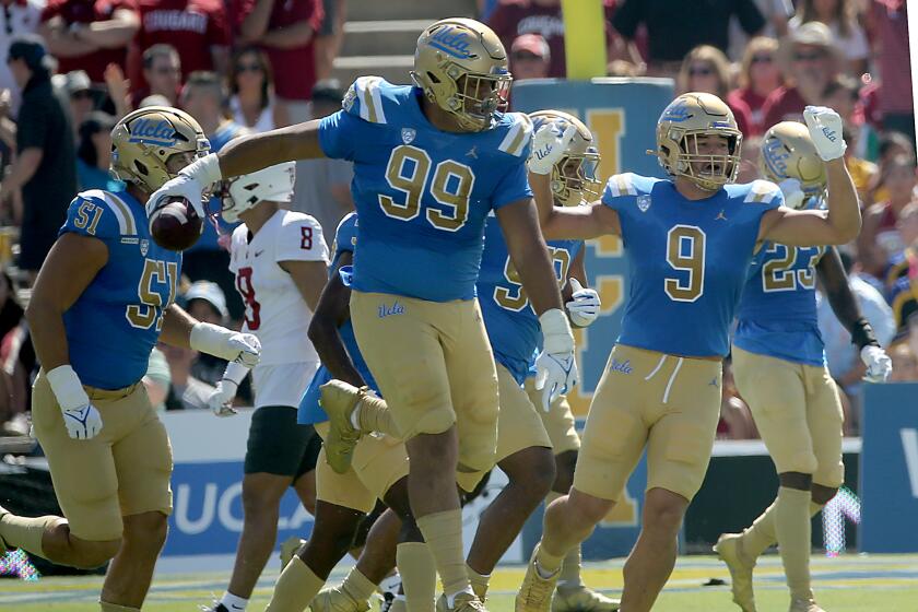 UCLA defensive lineman Keanu Williams (99) celebrates after recovering a fumble by Washington State quarterback Cam Williams