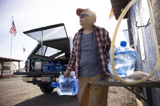Grant Greatorex, who lives just outside Bouse, fills jugs at a water filling station at Bouse RV Park.