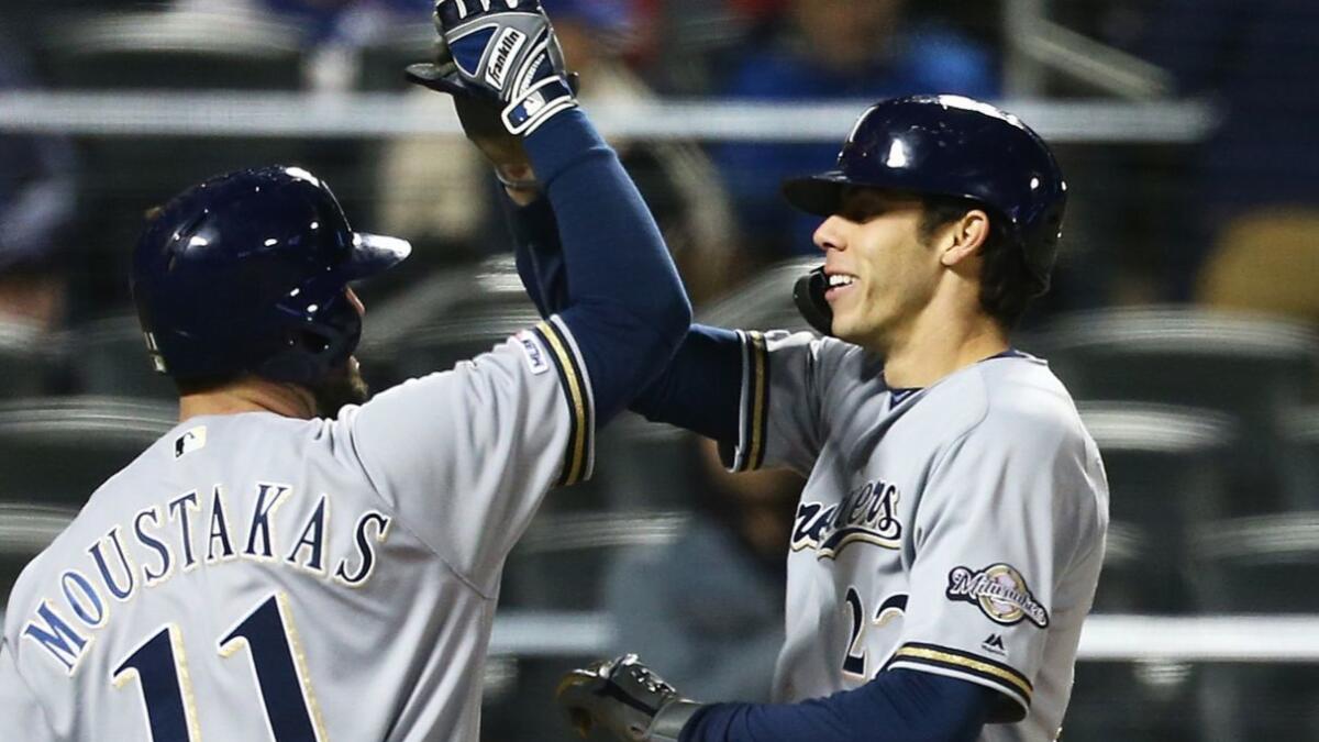 Brewers outfielder Christian Yelich celebrates with Mike Moustakas after hitting a home run against the Mets on Saturday.