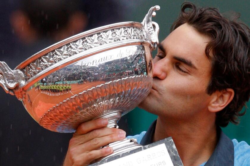 FILE - In this June 7, 2009, file photo, Switzerland's Roger Federer kisses his trophy after defeating Sweden's Robin Soderling in their men's singles final match of the French Open tennis tournament in Paris, France. Roger Federer says he won't play in the French Open and instead prepare to play on grass and hard courts later this season. Federer posted a message entitled "Roger to skip Roland Garros" on his website on Monday, May 15, 2017. (AP Photo/Christophe Ena, File)