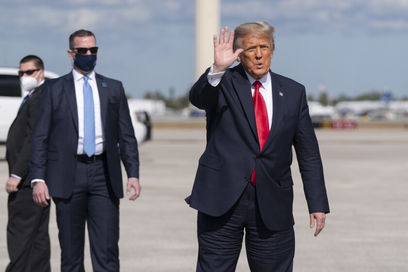 Former President Donald Trump waves at Palm Beach International Airport