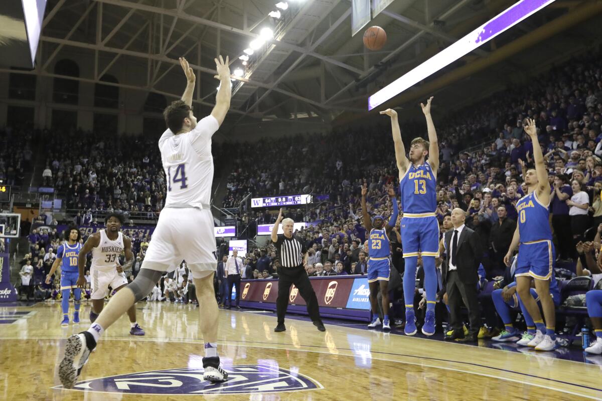 UCLA's Jake Kyman puts up a three-point shot with seconds left as Washington's Sam Timmins (14) is late to defend the shot on Jan. 2 in Seattle
