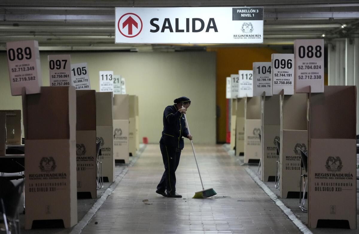 Una mujer limpia el principal centro de votación de la capital en preparación para la segunda vuelta 