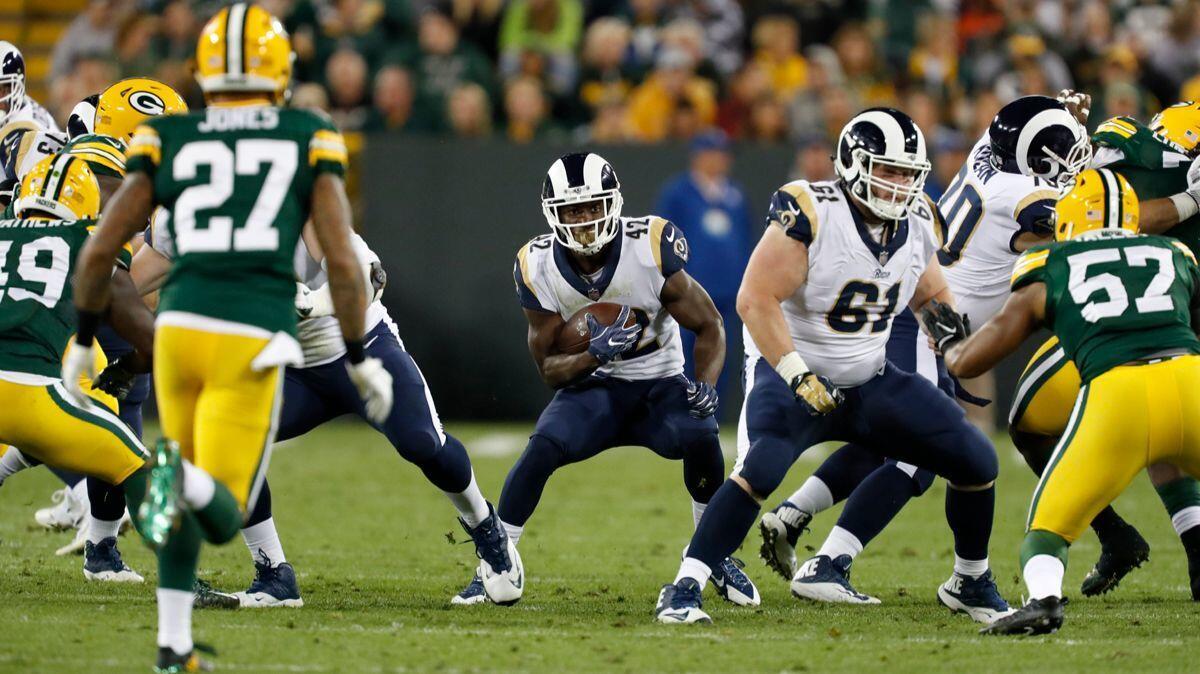 Rams' Justin Davis runs through Green Bay Packers defenders during the second half of a preseason game on Thursday.