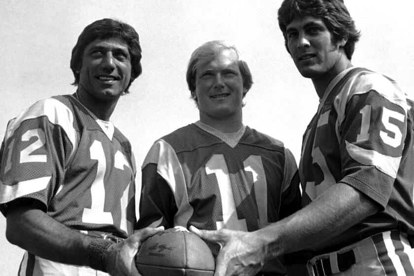 Rookie Vince Ferragamo (15) poses with veteran Rams quarterbacks Joe Namath (12) and Pat Haden (11) during training camp in 1977.