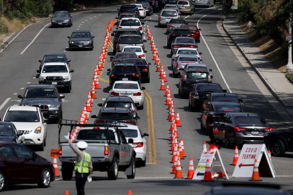 Cars line up for drive-through coronavirus testing at Dodger Stadium in Los Angeles.