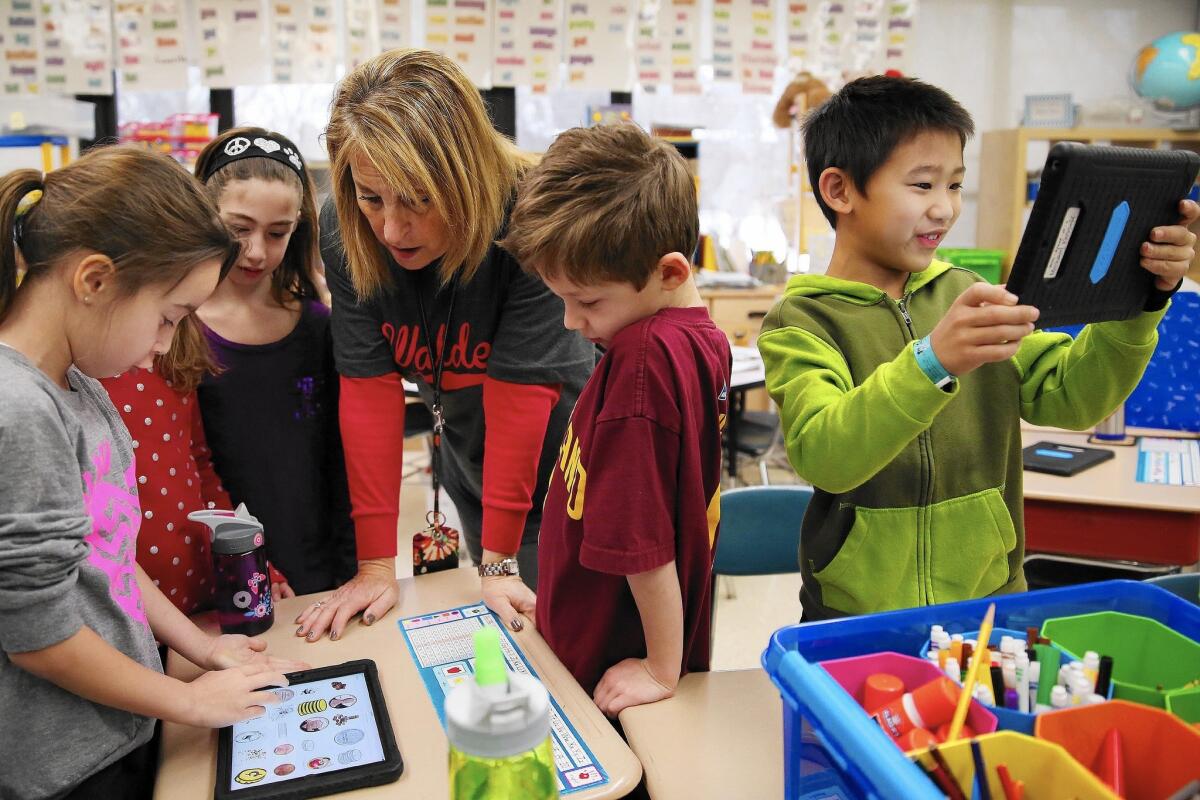 Andrew Zhu, right, uses his iPad for a lesson at Walden Elementary School in Deerfield, Ill.