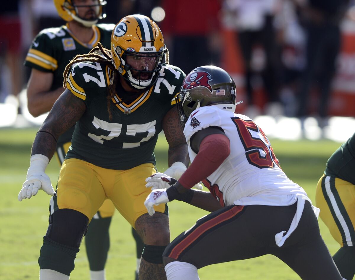 FILE - In this Oct. 18, 2020, file photo, Green Bay Packers offensive tackle Billy Turner (77) looks to block Tampa Bay Buccaneers outside linebacker Shaquil Barrett (58) during the first half of an NFL football game in Tampa, Fla. Turner has started six games at right tackle and three at left tackle this season. (AP Photo/Jason Behnken, File)