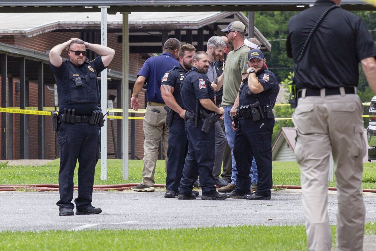 Officials gather outside Walnut Park Elementary School in Gadsden, Ala., following a fatal police shooting on Thursday, June 9, 2022. Authorities say a man who tried to enter an Alabama elementary school where a summer program was being held was shot to death by police.(Jesse Jarrold-Grapes/The Gadsden Times via AP)