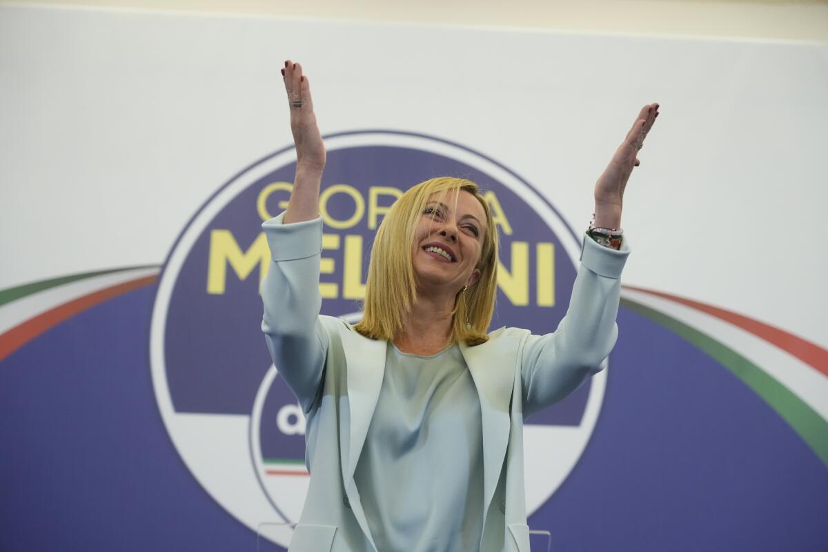 Italian far-right leader Giorgia Meloni raises her arms