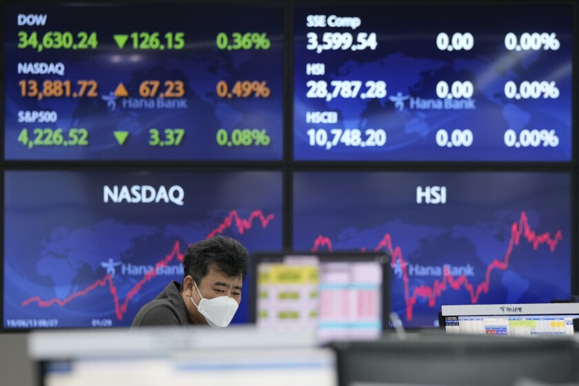 A currency trader watches monitors at the foreign exchange dealing room of the KEB Hana Bank headquarters in Seoul, South Korea, Tuesday, June 8, 2021. Stocks edged lower in Asia on Tuesday after a mixed finish on Wall Street, as investors weighed the risks of inflation against signs the recovery from the pandemic is gaining momentum. (AP Photo/Ahn Young-joon)
