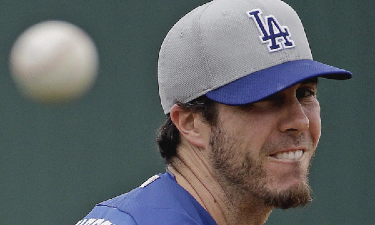 Dodgers pitcher Dan Haren throws during a Cactus League game against the Angels on Thursday. Haren is getting accustomed to his new role in the Dodgers' starting rotation.