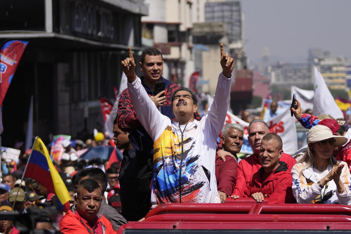 El presidente venezolano Nicolás Maduro señala al cielo mientras lo llevan a la Comisión