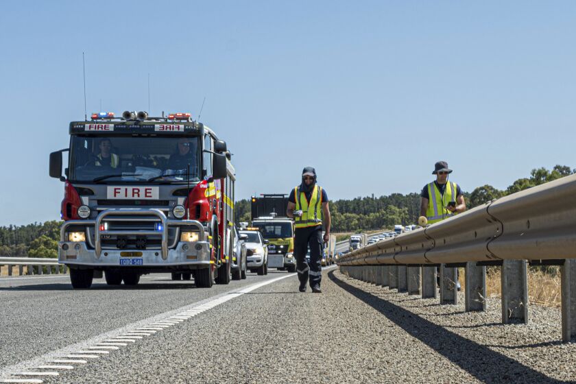En esta foto proporcionada del Departamento de Incendios y Servicios de Emergencias, sus miembros buscan una cápsula que se cree cayó de un camión durante su traslado en una ruta de mercancías a las afueras de Perth, Australia, el sábado 28 de junio de 2023. (Departamentp de Incendios y Servicios de Emergencia via AP)