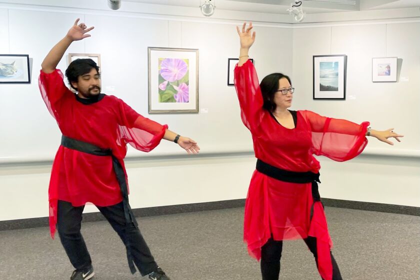 Pacific Beach Library staff members Rob Rosas and Christina Wainwright rehearsing the “Wuthering Heights” dance in the red tunics that will featured in the July 16 costuming workshop.