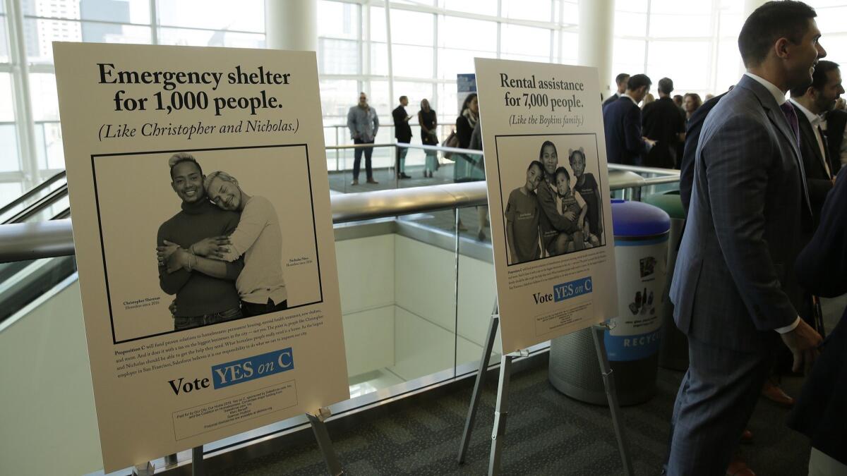 Signs urge support for Proposition C at a SPUR luncheon in San Francisco on Oct. 30. The measure on San Francisco's ballot Tuesday would levy an extra tax on hundreds of the city's wealthiest companies to raise $300 million for homelessness and mental health services.