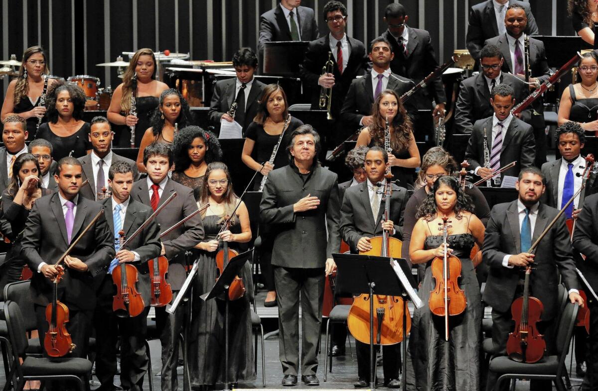 Bahia Orchestra Project conductor Ricardo Castro, center, and the 100-member youth orchestra from Brazil acknowledge the audience during a performance at the Valley Performing Arts Center in Northridge.