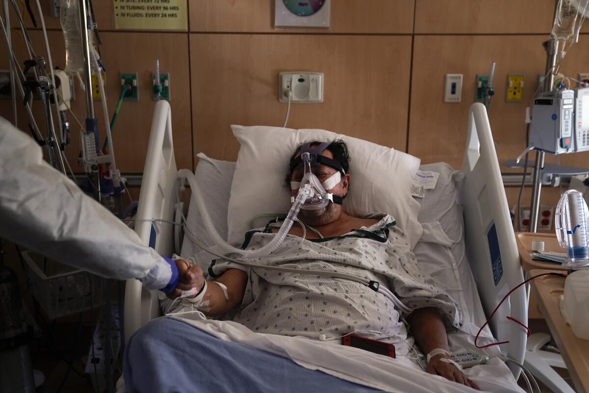 COVID-19 patient Efrain Molina gets a fist bump from nurse leader Edgar Ramirez at Providence Holy Cross.