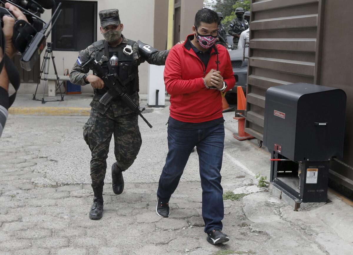 An alleged mastermind of the murder of Honduran environmental and Indigenous rights activist Berta Caceres, Roberto David Castillo is escorted by a police officer upon his arrival to the Supreme Court in Tegucigalpa, Honduras, Tuesday, April 6, 2021. Catillo’s trial began five years after the prize-winning activist's murder. (AP Photo/Elmer Martinez)