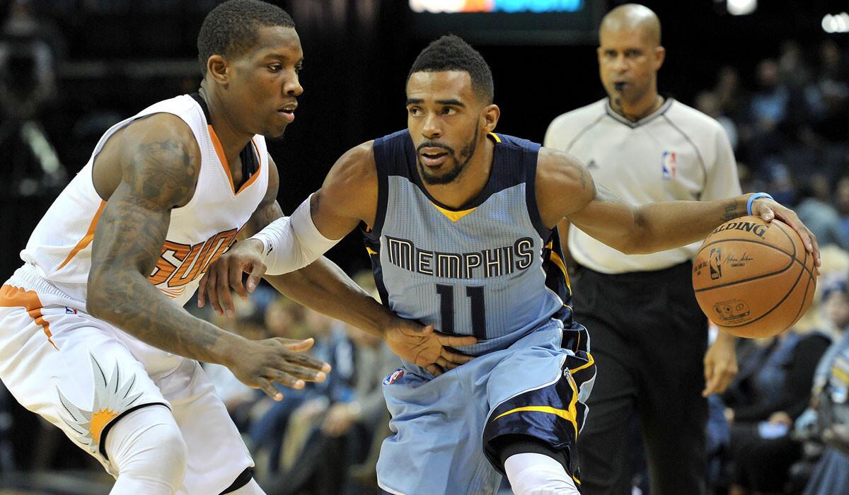 Grizzlies guard Mike Conley (11) looks to drive against Suns guard Eric Bledsoe in the first half Sunday in Memphis.