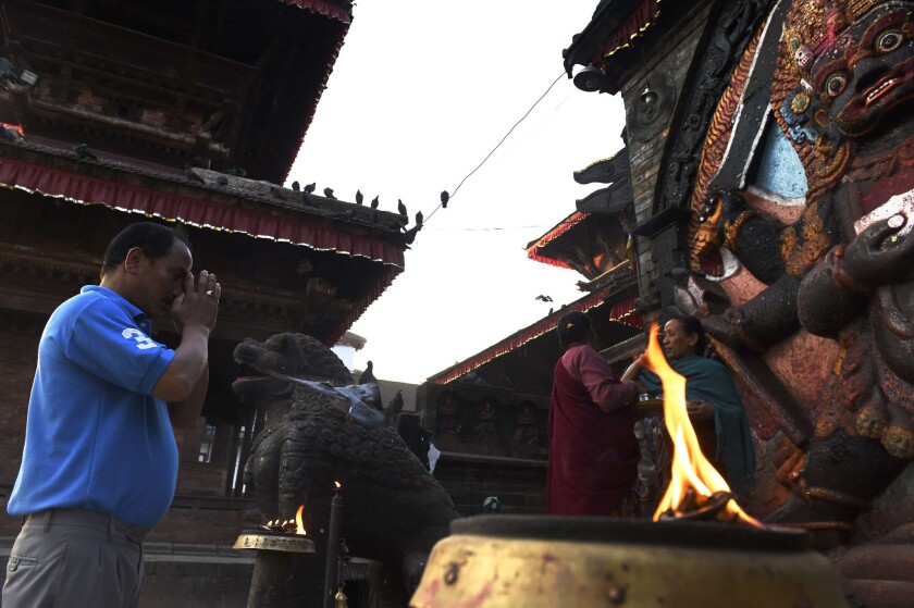A man offers prayers at a statue of Hindu diety Kaal Bhairab in the Durbar Square neighborhood of Katmandu.