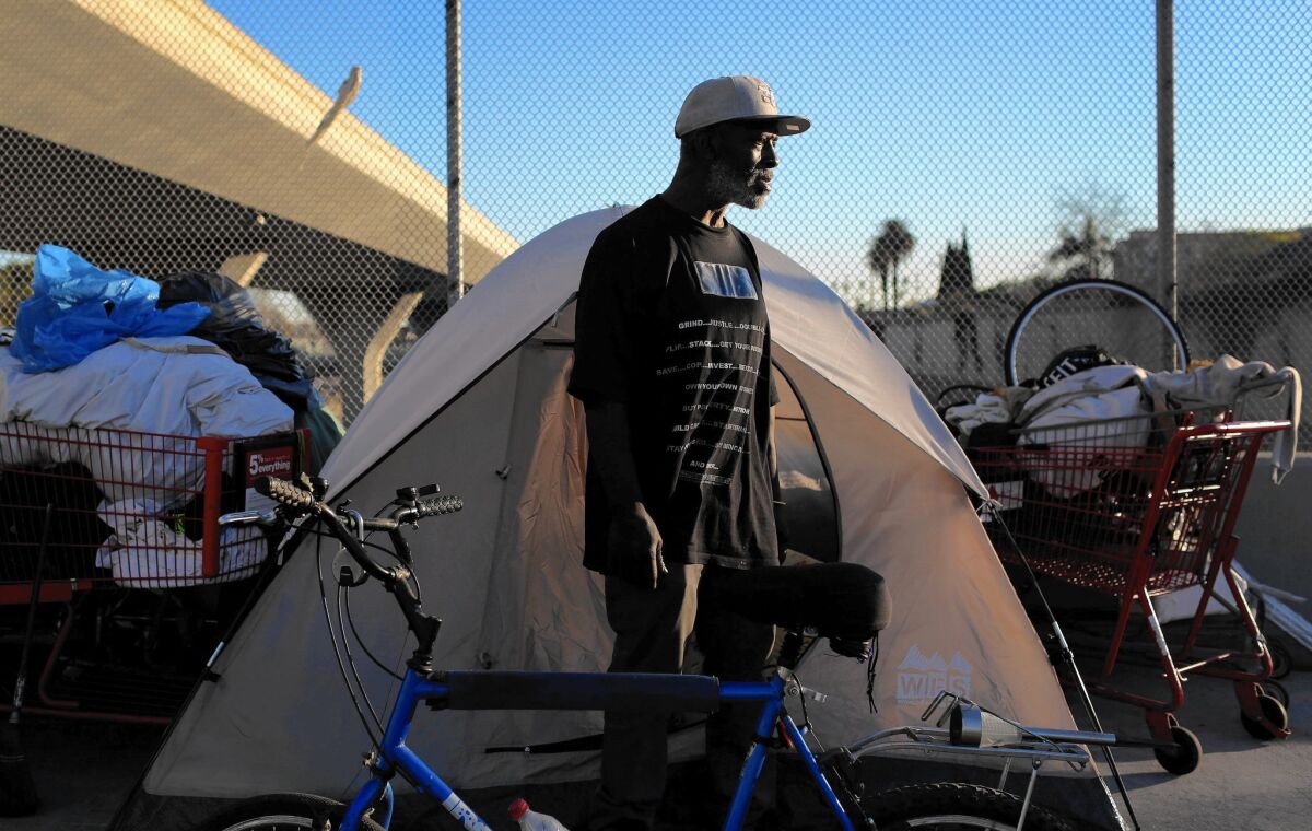 Willie Hadnot stands outside his tent on the 42nd Street overpass over the 110 Freeway. Activists last fall urged L.A. to declare a state of emergency as severe weather threatened the city's homeless population.