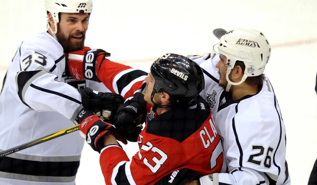 Defensemen Willie Mitchell, left, and Slava Voynov (26) helped the Kings win Stanley Cup titles over the Devils in 2012 and Rangers last season. The team's defense has suffered this season with neither in the lineup.