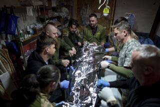 Médicos militares ucranianos colocan a un camarada herido en una camilla en un hospital de campaña en dirección a Avdiivka, en la región de Donetsk, Ucrania, el viernes 10 de mayo de 2024. (AP Foto/Evgeniy Maloletka)