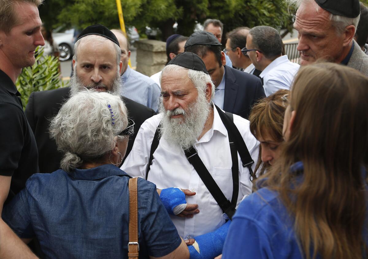 Rabbi Yisroel Goldstein, center, meets with members of the congregation of Chabad of Poway the day after a deadly shooting.