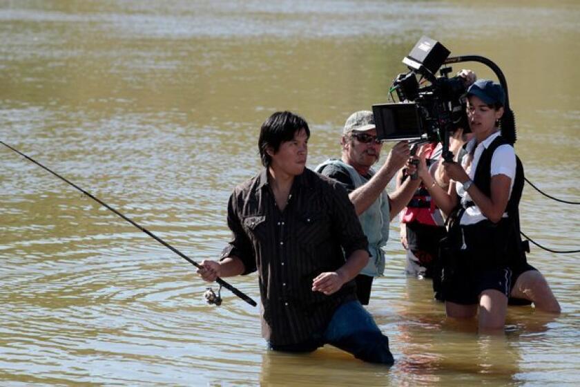 The camera follows lead actor Chaske Spencer into the water during filming of "Winter in the Blood" near Chinook, Mont., in 2011.