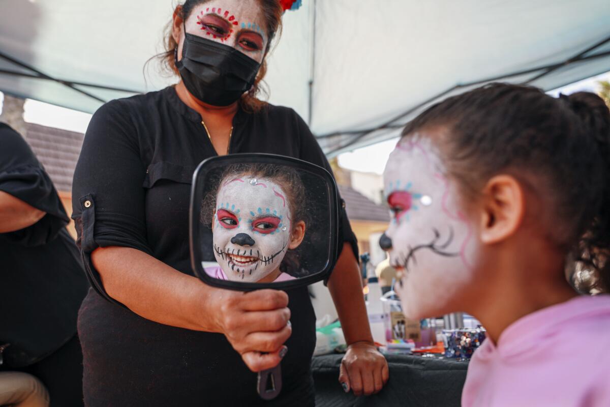 Savaya Taylor, 5, had her face painted by Gregoria Martinez during the Oceanside Dia de los Muertos Festival 