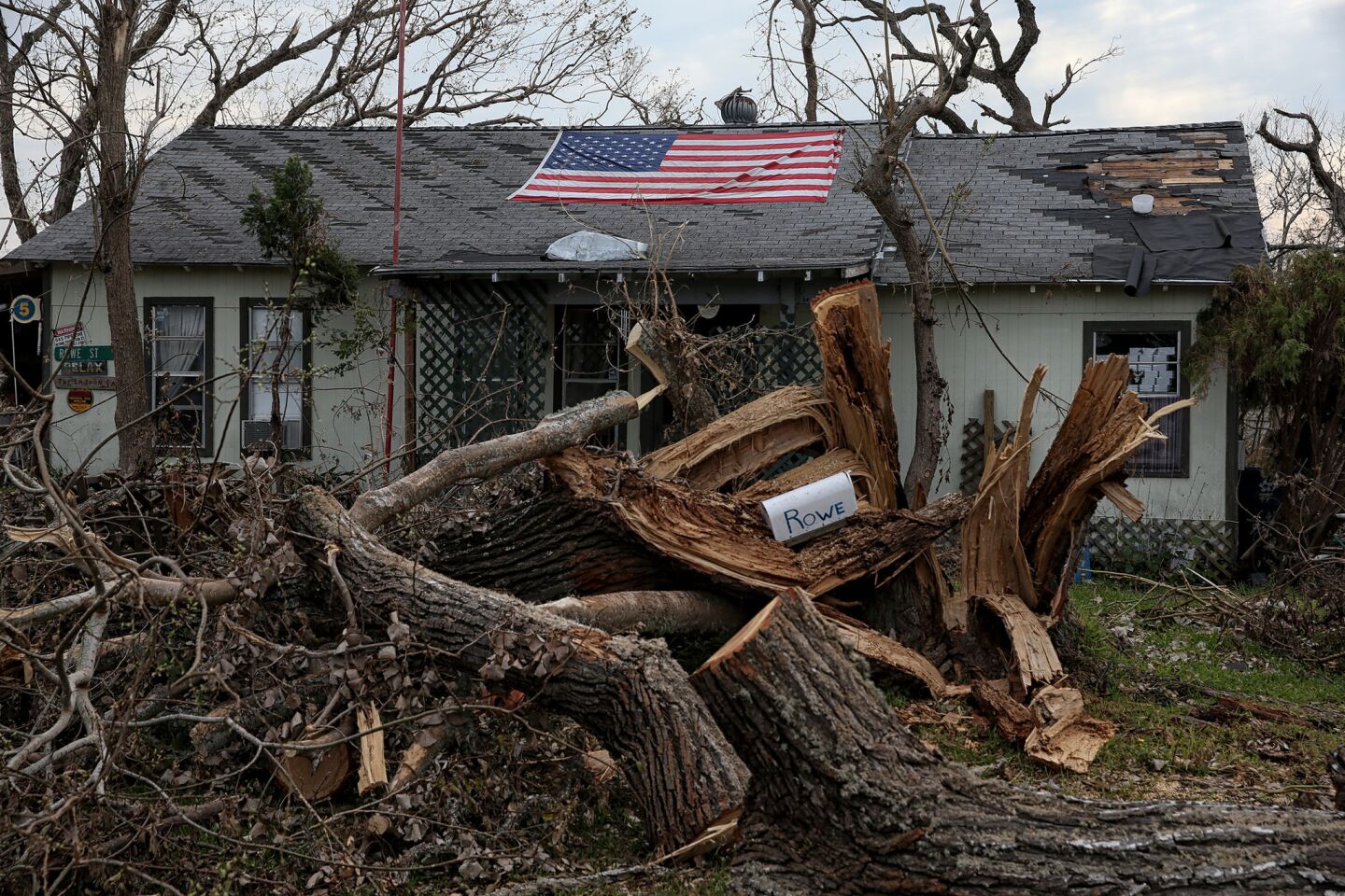 Despite heavy damage and no electricity, a homeowner displays his patriotism while clean up and recovery efforts continue in his devastated neighborhood of Rockport.