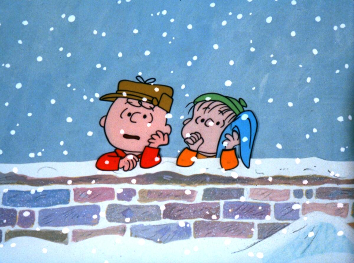 Charlie Brown and Linus lean against a snow-covered wall pondering the meaning of Christmas