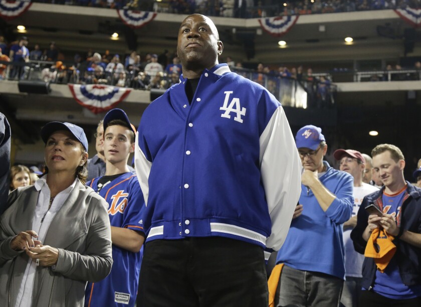 Dodgers minority owner and former Lakers star Magic Johnson watches pregame activities before the start of a Dodgers playoff game.