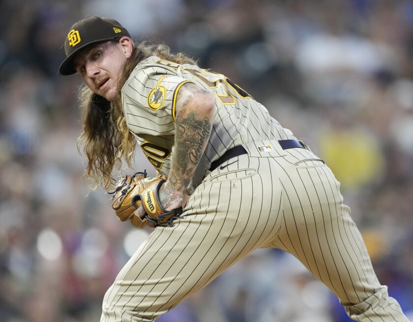 Padres pitcher Mike Clevinger checks a runner on first base during Friday's game against the Rockies