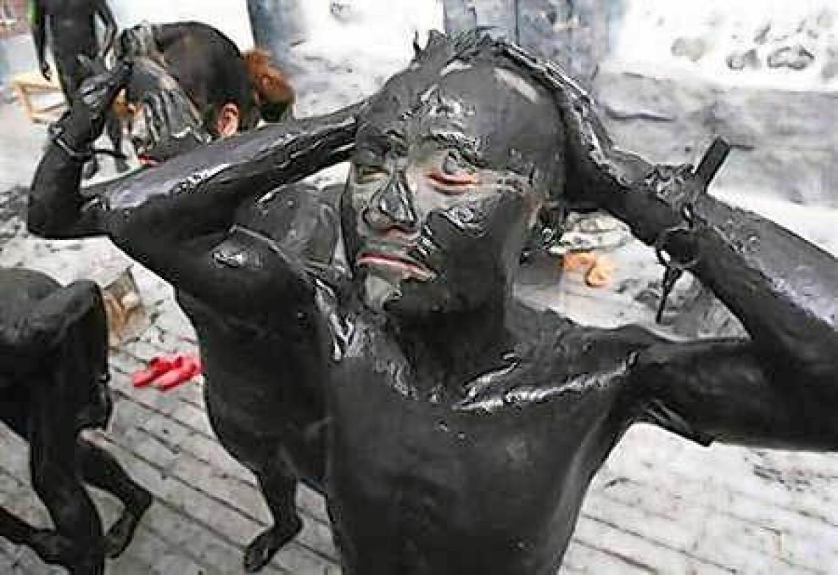 Visitors cover their bodies with black mud at a tourist resort in Daying County of Suning, south-western China's Sichuan province.