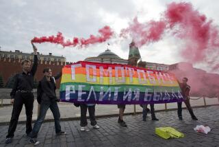 FILE - Gay rights activists hold a banner reading "Homophobia - the religion of bullies" during their action in protest at homophobia, on Red Square in Moscow, Russia, on July 14, 2013. Russian lawmakers on Wednesday June 14, 2023 approved in first reading a bill outlawing gender-affirming medical care and changing gender in official documents in yet another crippling blow to Russia's already beleaguered LGBTQ+ community. (AP Photo/Evgeny Feldman, File)