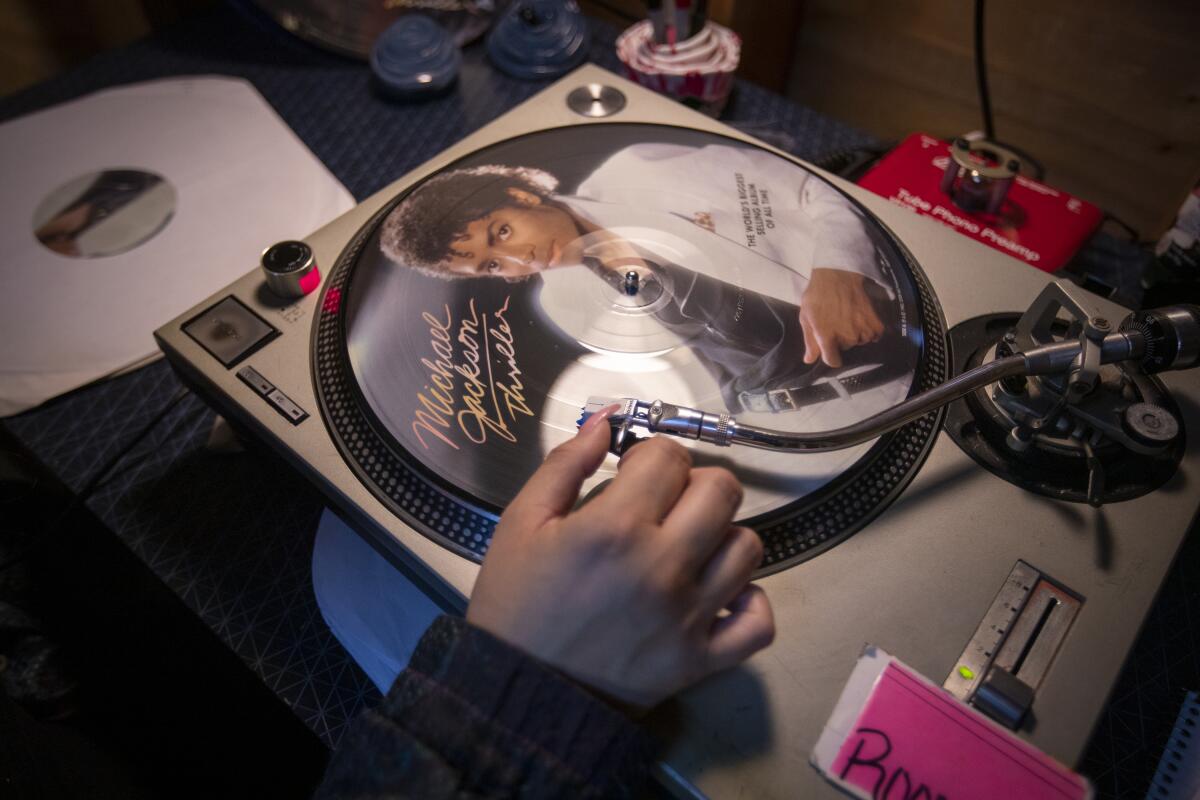 A woman listens to a Michael Jackson Thriller picture record