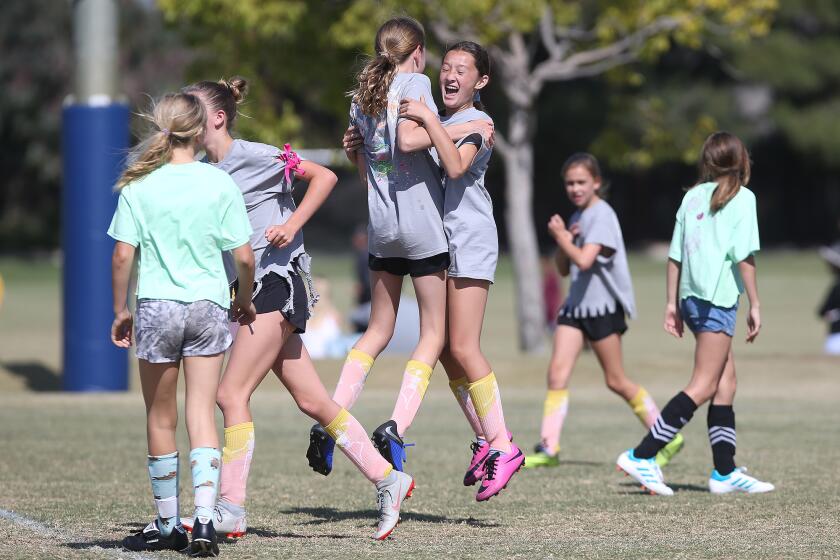 Newport Beach Our Lady Queen of Angels' Kyla Grant, in pink shoes, celebrates with a teammate after she scored a goal against Newport Beach Eastbluff in the the girls’ fifth- and sixth-grade Silver Division pool-play match at the Daily Pilot Cup in Costa Mesa on Wednesday.
