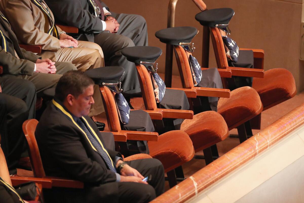 Reserved seats contain American flags and police hats during an interfaith memorial service, honoring five slain police officers, at the Morton H. Meyerson Symphony Center on July 12, 2016 in Dallas, Texas.