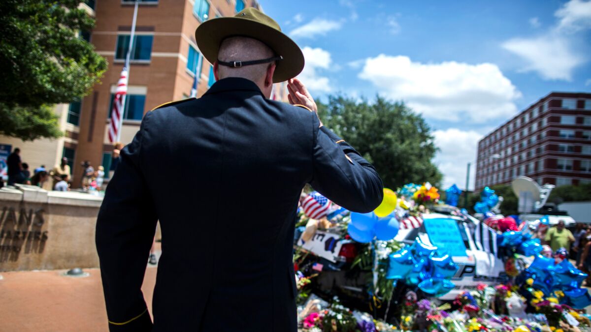 Retired Army Sgt. Chandler Davis pays his respects at a growing memorial in front of the Dallas police headquarters.