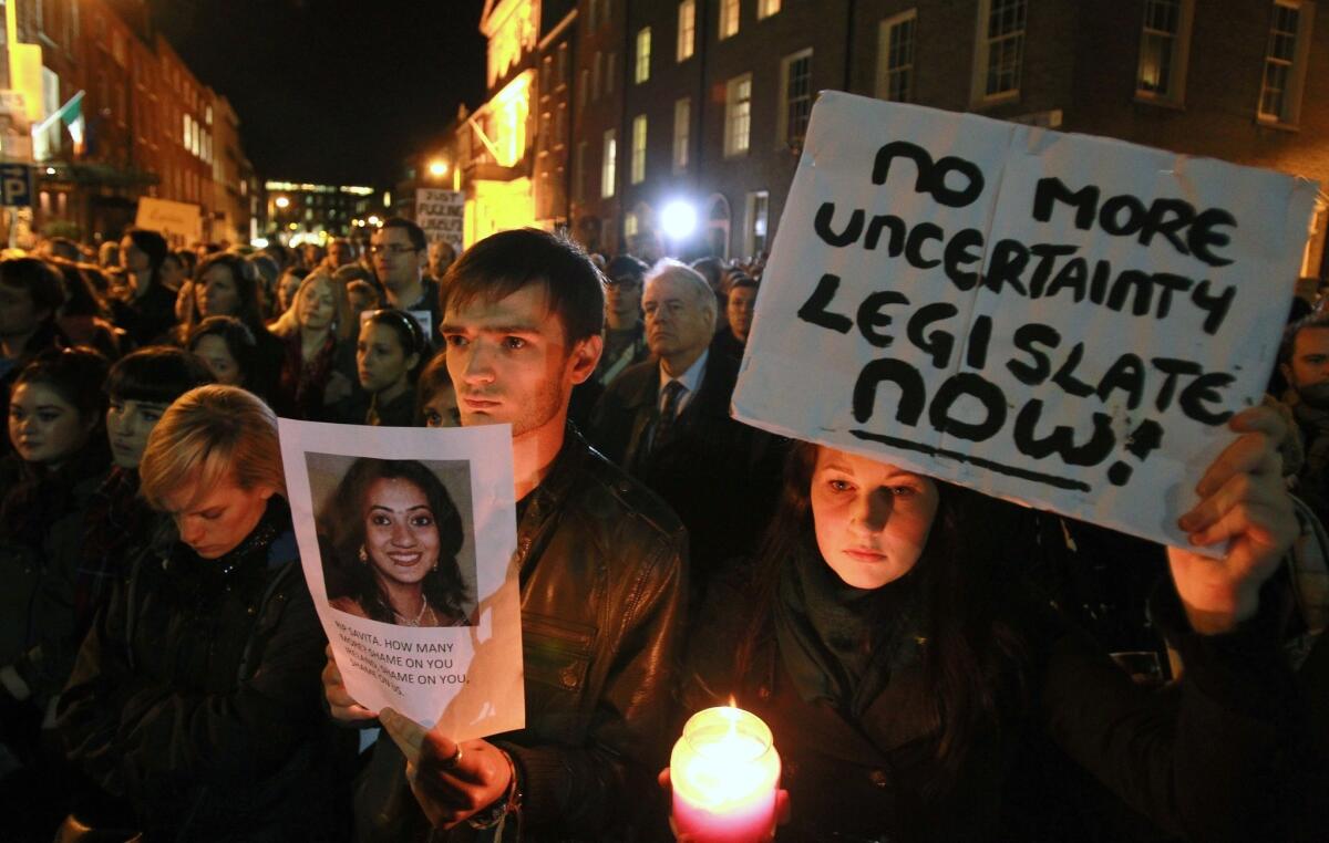 Protesters in Dublin hold pictures of Savita Halappanavar as they gather outside the Irish Parliament building Nov. 14 during a demonstration in favor of abortion legislation.