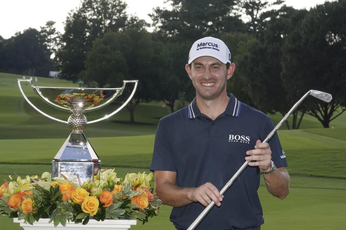Patrick Cantlay poses with the trophies after winning the Tour Championship golf tournament and the FedEx Cup at East Lake Golf Club, Sunday, Sept. 5, 2021, in Atlanta. (AP Photo/Brynn Anderson)