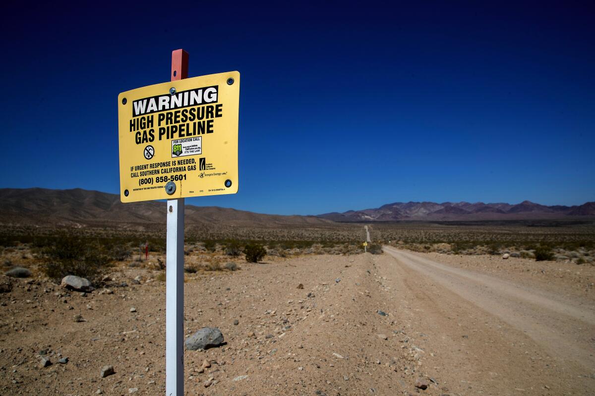 A sign warns of a SoCalGas pipeline running through the California desert toward the Los Angeles Basin.