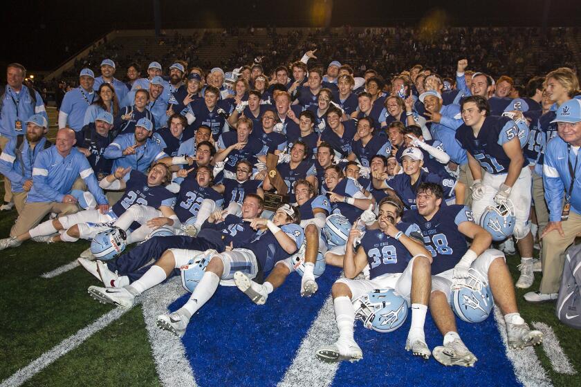 Corona del Mar football team celebrates after defeating Serra 35-27 in the CIF State a Division 1-A title game at Cerritos College on Saturday.