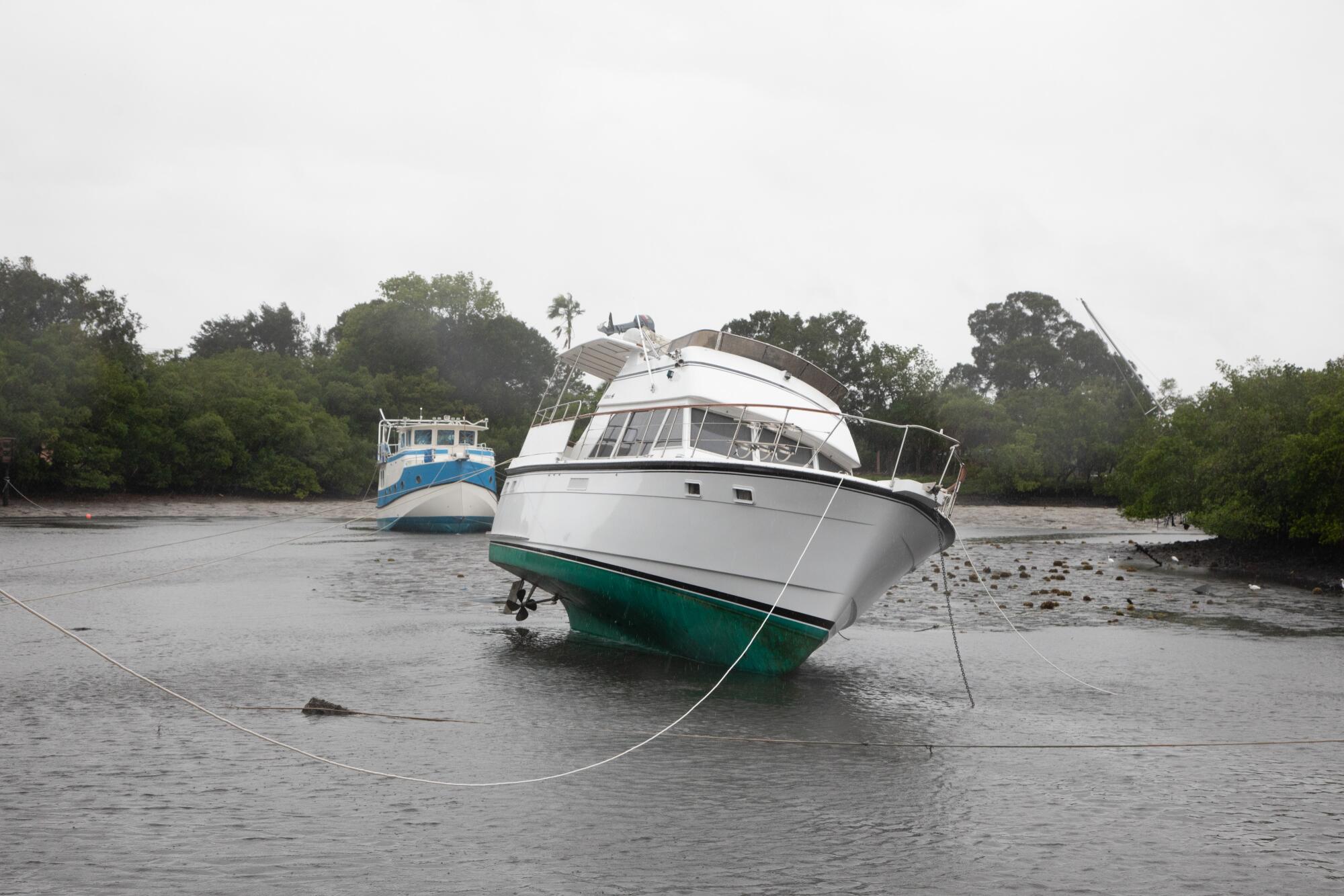 A boat sways in shallow water as Hurricane Ian approaches a neighborhood in St. Petersburg, Fla.