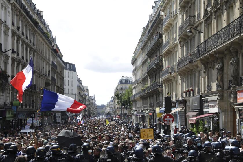 Banderas francesas ondean durante una marcha de miles de manifestantes en París, Francia, el sábado 31 de julio de 2021. (AP Foto/Adrienne Surprenant)