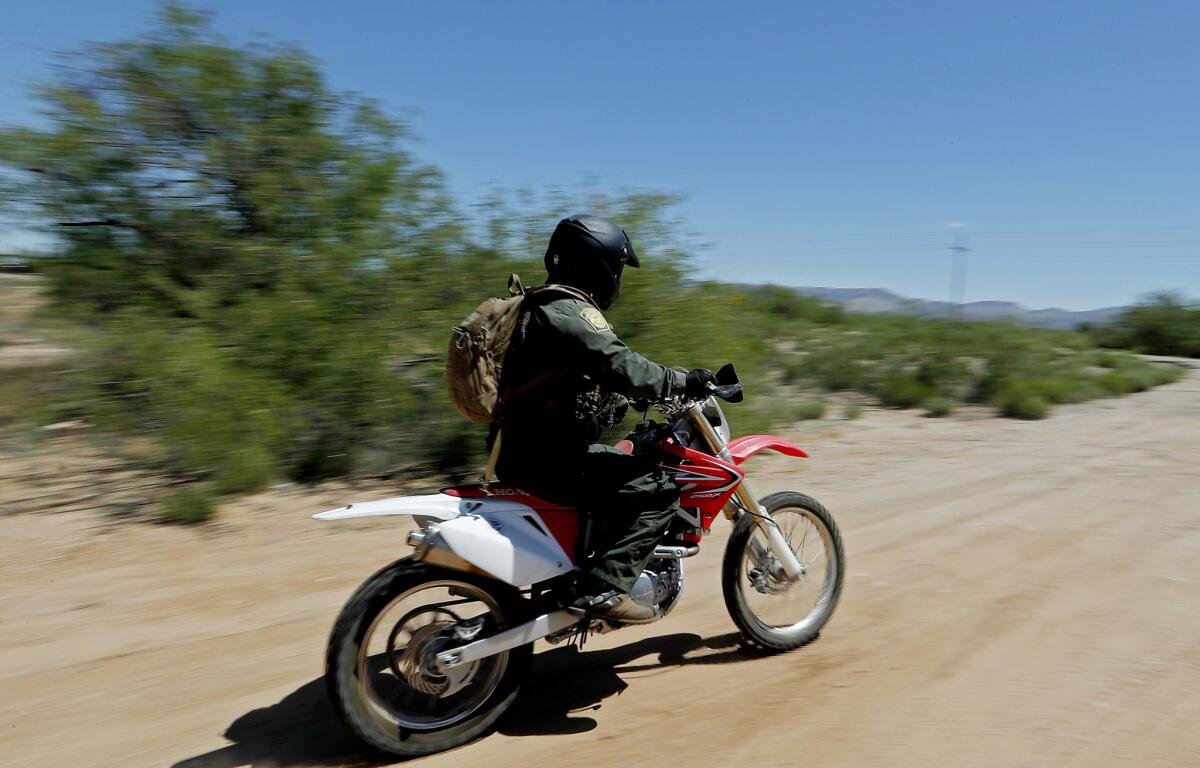 A Border Patrol agent uses a motorcycle to work a stretch of the U.S.-Mexico border in the Tohono O'odham Nation. (Luis Sinco / Los Angeles Times)