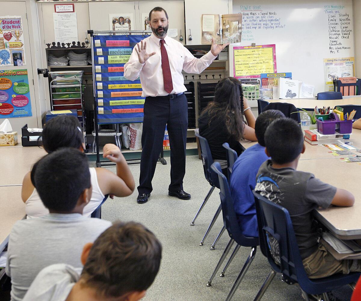 In this September 2012 file photo, Burbank Unified School District's Dr. Tom Kissinger, Director of Elementary Education, reads to a group of fifth graders at Providence Elementary School as part of the school's Literature Week. Students in Burbank Unified landed above state and county averages for their scores on the new standardized exams, according to data released on Wednesday, but they ranked lower than their peers in neighboring districts, including Glendale and La Cañada.